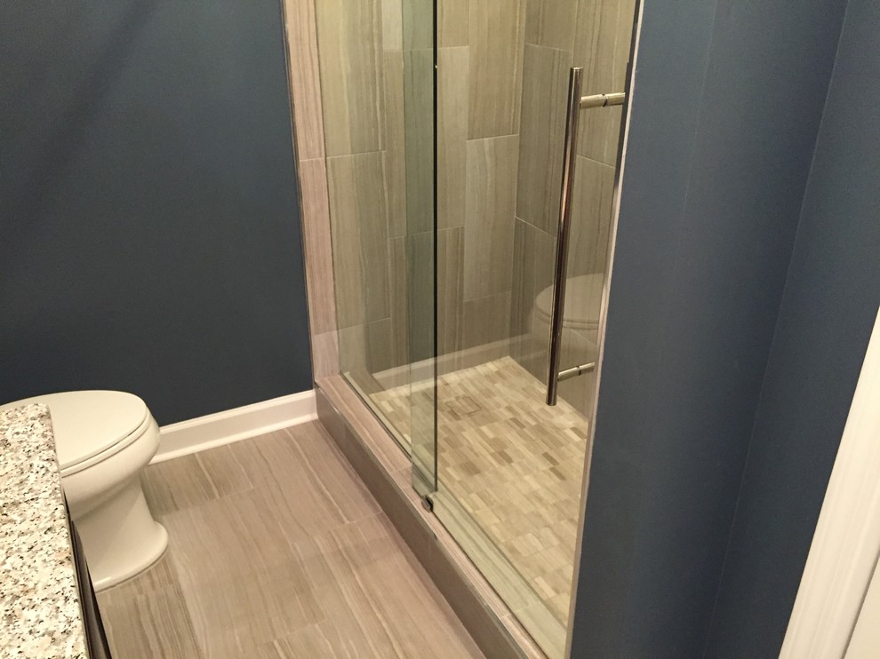 Idéer för att renovera ett mellanstort vintage badrum med dusch, med ett undermonterad handfat, luckor med infälld panel, skåp i mörkt trä, granitbänkskiva, en dusch i en alkov, en toalettstol med separat cisternkåpa, grå kakel, porslinskakel, blå väggar och klinkergolv i porslin
