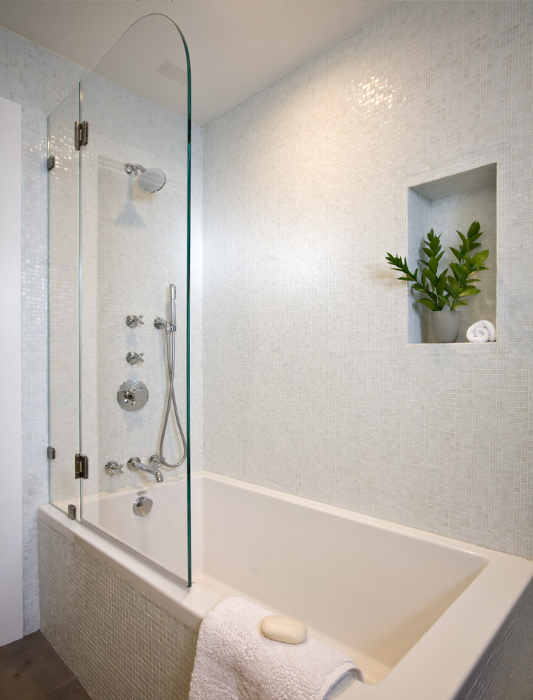 Imagen de cuarto de baño contemporáneo de tamaño medio con bañera esquinera, sanitario de dos piezas, baldosas y/o azulejos blancos, paredes blancas, suelo de piedra caliza y lavabo encastrado