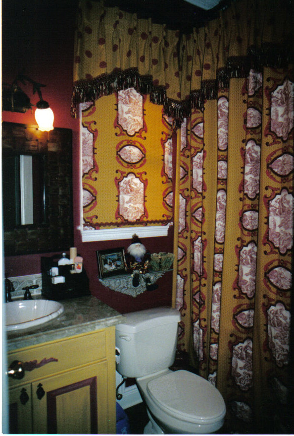 Idée de décoration pour une petite salle d'eau tradition avec un placard avec porte à panneau surélevé, des portes de placard jaunes, une baignoire en alcôve, un combiné douche/baignoire, un carrelage marron, des carreaux de céramique, un mur beige, sol en béton ciré, un lavabo posé et un plan de toilette en marbre.