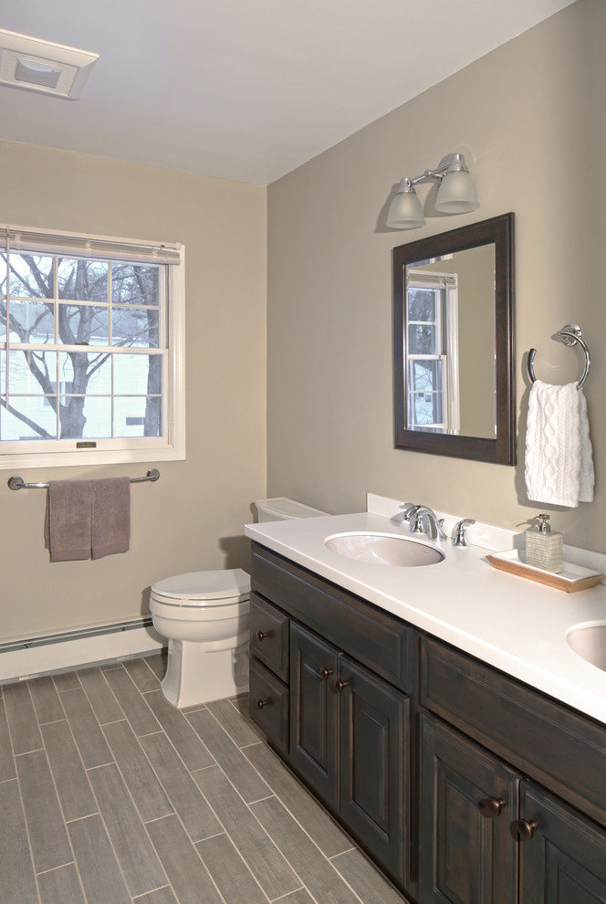 Foto di una stanza da bagno tradizionale di medie dimensioni con lavabo sottopiano, piastrelle grigie e pareti grigie