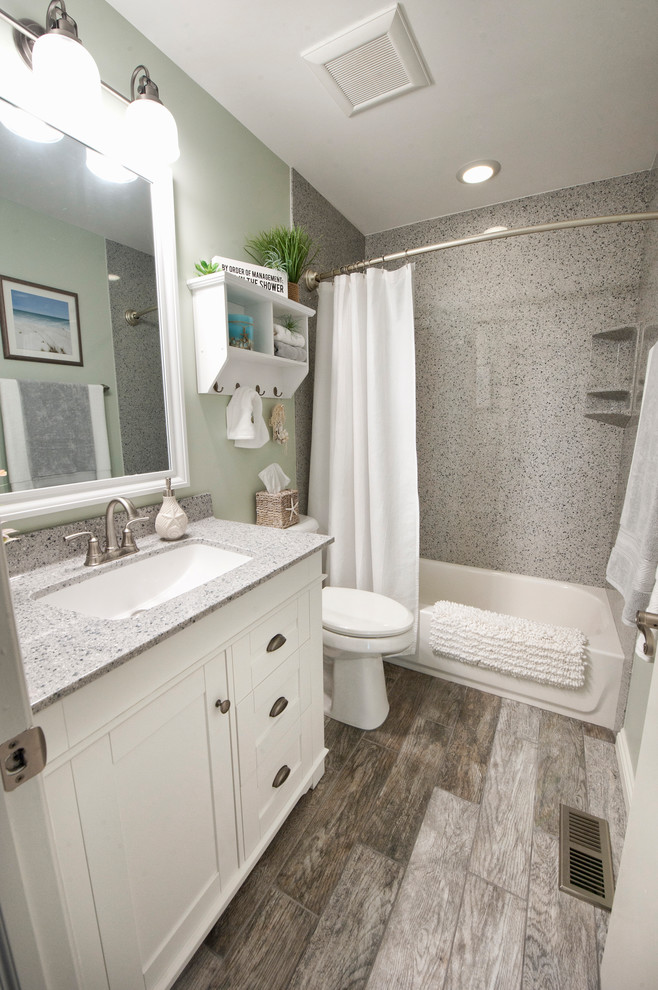 Small coastal bathroom in Columbus with white cabinets, green tiles, ceramic flooring and grey floors.