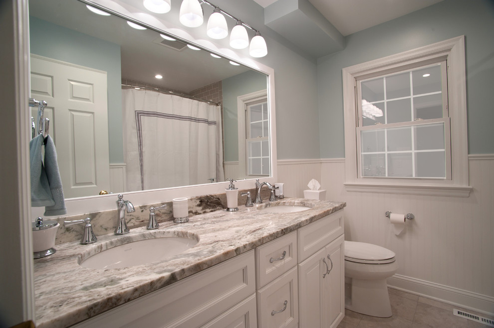 Источник вдохновения для домашнего уюта: главная ванная комната среднего размера в стиле неоклассика (современная классика) с ванной в нише, душем над ванной, раздельным унитазом, плиткой кабанчик, серыми стенами, врезной раковиной, серым полом, шторкой для ванной, фасадами с утопленной филенкой, белыми фасадами, столешницей из гранита и разноцветной столешницей
