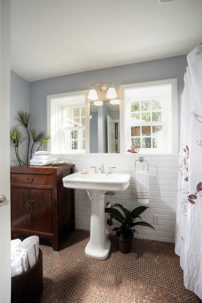 Modelo de cuarto de baño tradicional con combinación de ducha y bañera, sanitario de una pieza, paredes grises y lavabo con pedestal