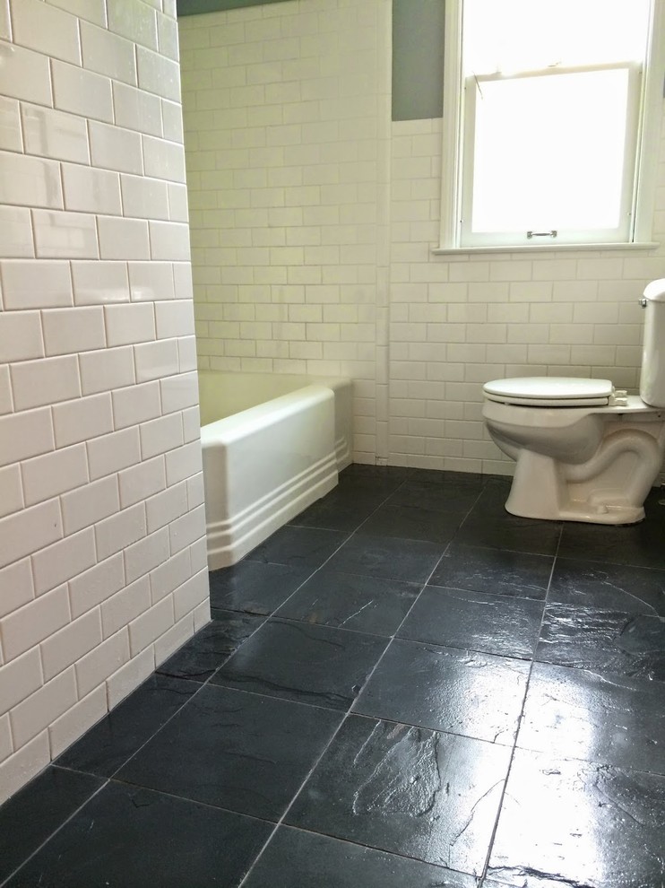 На фото: ванная комната среднего размера в стиле кантри с накладной ванной, душем над ванной, раздельным унитазом, белой плиткой, керамической плиткой, серыми стенами, полом из сланца, раковиной с пьедесталом, черным полом и шторкой для ванной с