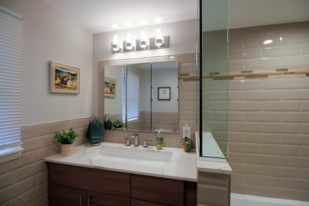 Medium sized contemporary family bathroom in New York with flat-panel cabinets, brown cabinets, an alcove bath, a shower/bath combination, a two-piece toilet, beige tiles, porcelain tiles, beige walls, porcelain flooring, a trough sink, engineered stone worktops, white floors, a shower curtain, white worktops, a single sink and a built in vanity unit.