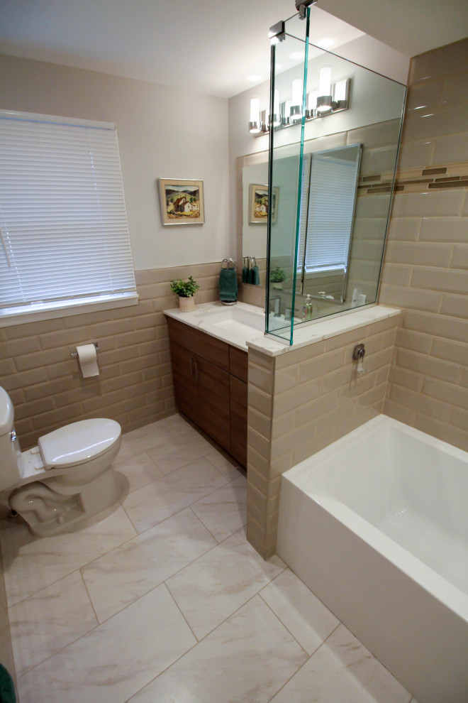 Design ideas for a medium sized contemporary family bathroom in New York with flat-panel cabinets, brown cabinets, an alcove bath, a shower/bath combination, a two-piece toilet, beige tiles, porcelain tiles, beige walls, porcelain flooring, a trough sink, engineered stone worktops, white floors, a shower curtain, white worktops, a single sink and a built in vanity unit.