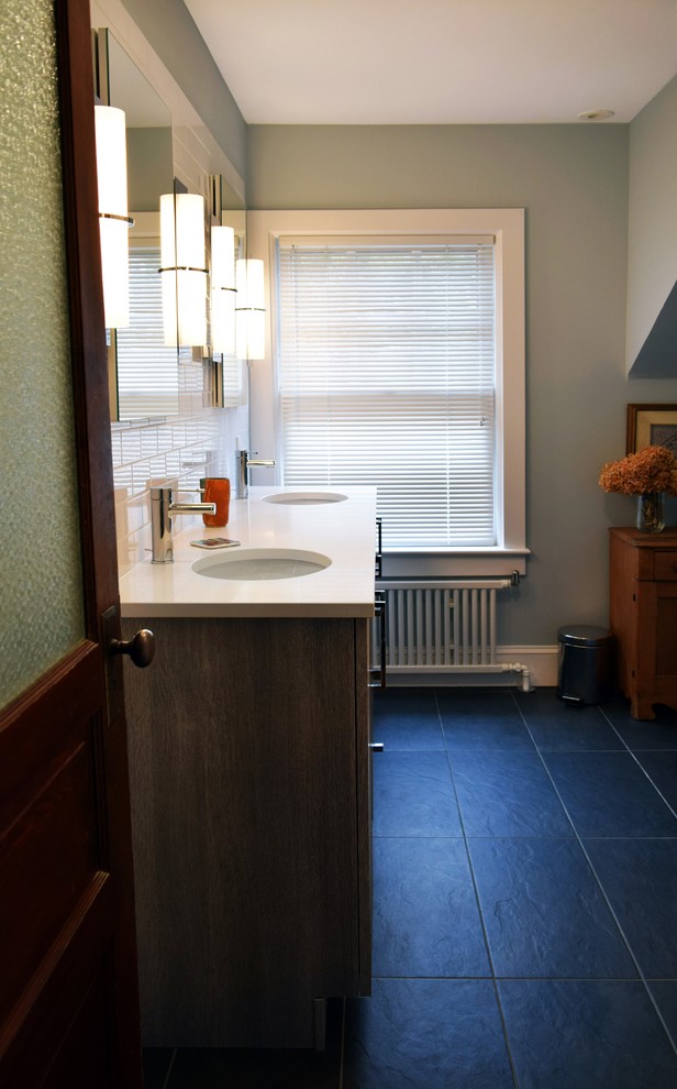Cette photo montre une salle de bain tendance de taille moyenne avec des portes de placard grises, une baignoire en alcôve, un combiné douche/baignoire, WC à poser, un carrelage bleu, un carrelage métro, un mur bleu, un sol en carrelage de porcelaine, un lavabo encastré, un plan de toilette en quartz modifié, un sol gris et une cabine de douche avec un rideau.