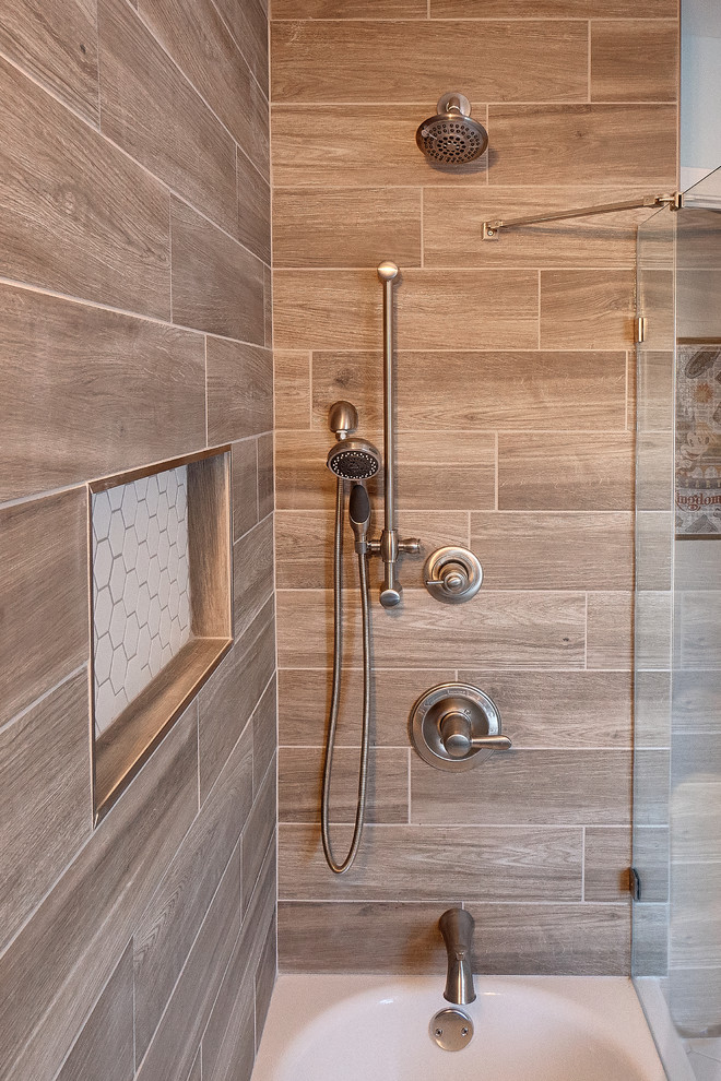 Example of a mid-sized transitional kids' brown tile and porcelain tile porcelain tile and gray floor bathroom design in Philadelphia with recessed-panel cabinets, medium tone wood cabinets, a two-piece toilet, brown walls, an undermount sink, limestone countertops and gray countertops