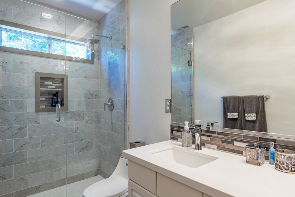 Exempel på ett litet klassiskt vit vitt badrum med dusch, med släta luckor, beige skåp, en kantlös dusch, en toalettstol med hel cisternkåpa, flerfärgad kakel, glaskakel, vita väggar, ett integrerad handfat, laminatbänkskiva, dusch med gångjärnsdörr, skiffergolv och svart golv
