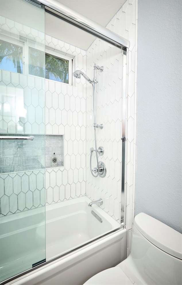 Inspiration for a small shower room bathroom in Denver with recessed-panel cabinets, white cabinets, an alcove bath, an alcove shower, a one-piece toilet, white tiles, porcelain tiles, blue walls, porcelain flooring, a submerged sink, engineered stone worktops, grey floors, a sliding door and white worktops.