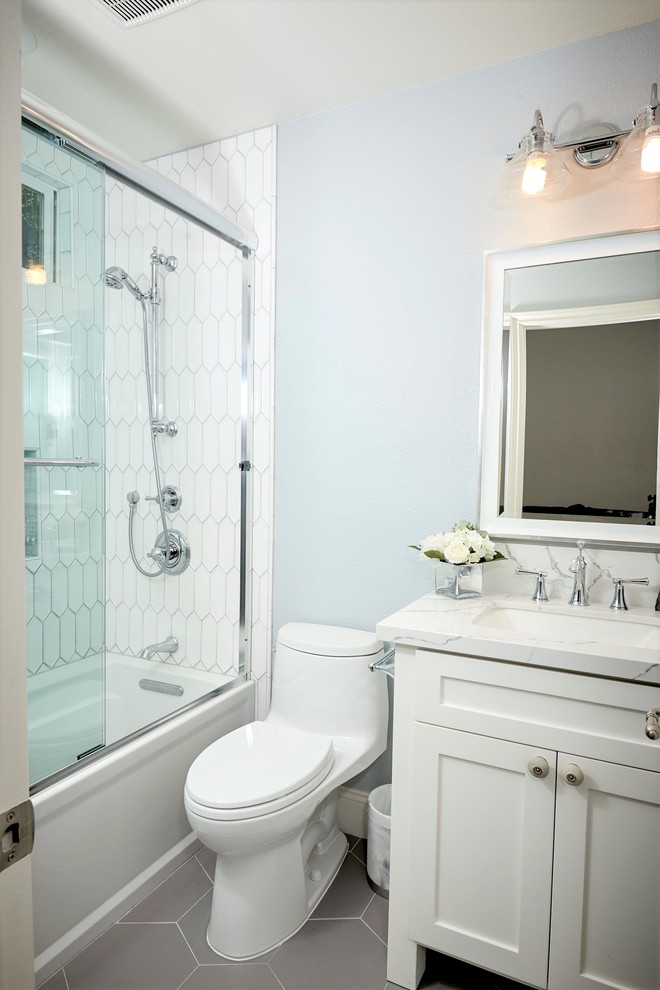 Example of a small 3/4 white tile and porcelain tile porcelain tile and gray floor bathroom design in Denver with recessed-panel cabinets, white cabinets, a one-piece toilet, blue walls, an undermount sink, quartz countertops and white countertops