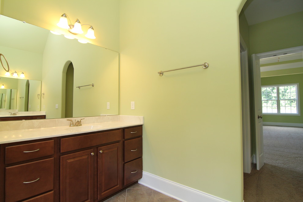 Стильный дизайн: большая главная ванная комната в классическом стиле с фасадами с выступающей филенкой, темными деревянными фасадами, ванной в нише, угловым душем, унитазом-моноблоком, бежевой плиткой, керамической плиткой, зелеными стенами и полом из керамической плитки - последний тренд