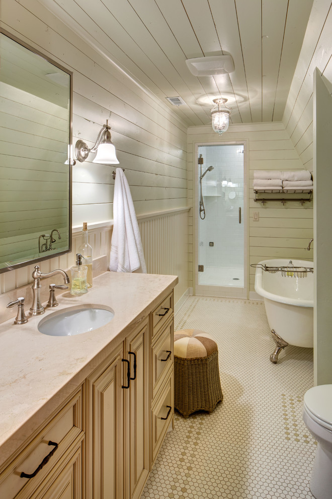 Immagine di una stanza da bagno tradizionale con vasca con piedi a zampa di leone, lavabo sottopiano e top beige