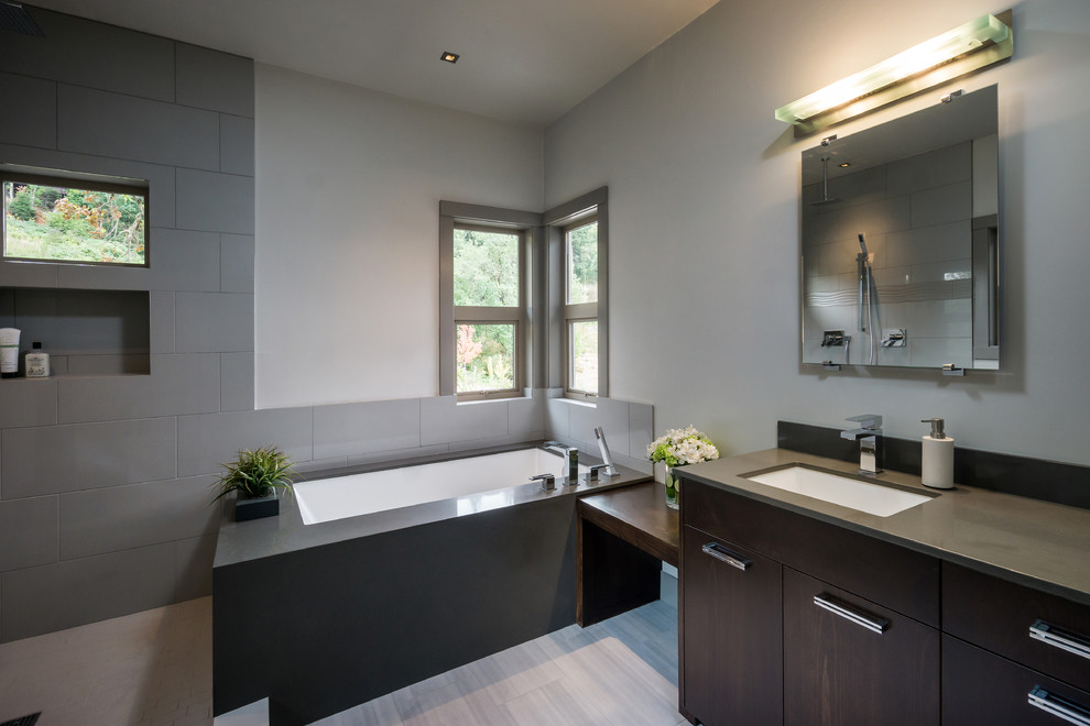 Example of a mid-sized minimalist gray tile and porcelain tile porcelain tile bathroom design in Other with an undermount sink, flat-panel cabinets, dark wood cabinets, quartz countertops, a one-piece toilet and gray walls