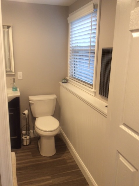 Photo of a contemporary bathroom in Philadelphia with raised-panel cabinets, dark wood cabinets and light hardwood flooring.