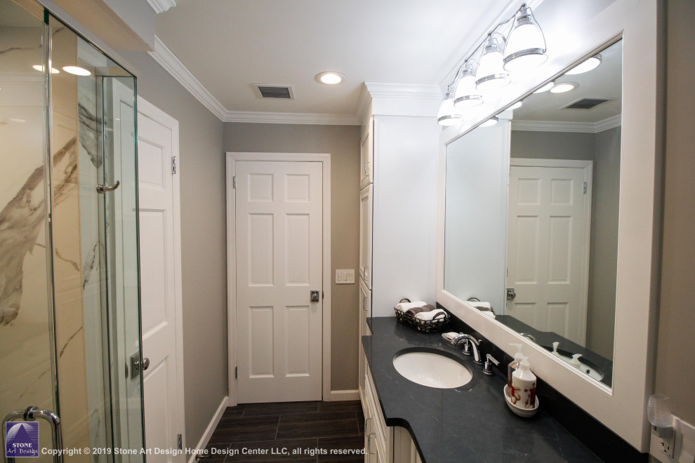 Свежая идея для дизайна: ванная комната среднего размера в стиле неоклассика (современная классика) с плоскими фасадами, белыми фасадами, душем в нише, раздельным унитазом, белой плиткой, керамогранитной плиткой, серыми стенами, полом из керамогранита, душевой кабиной, врезной раковиной, столешницей из искусственного кварца, черным полом, душем с распашными дверями, серой столешницей, сиденьем для душа, тумбой под одну раковину и встроенной тумбой - отличное фото интерьера