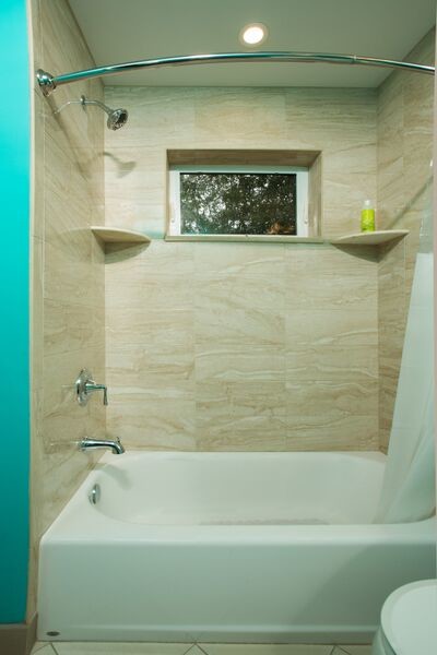 Bild på ett litet vintage badrum för barn, med ett undermonterad handfat, släta luckor, skåp i mörkt trä, marmorbänkskiva, ett badkar i en alkov, en dusch i en alkov, en toalettstol med hel cisternkåpa, beige kakel, porslinskakel, blå väggar och klinkergolv i porslin