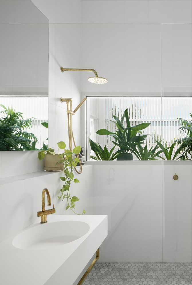Modelo de cuarto de baño escandinavo con paredes blancas, lavabo integrado, suelo gris y encimeras blancas