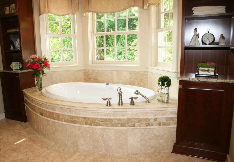 Mid-sized elegant master beige tile and ceramic tile ceramic tile and beige floor corner shower photo in New York with dark wood cabinets, granite countertops, a hot tub, a two-piece toilet, beige walls, raised-panel cabinets, an undermount sink and a hinged shower door