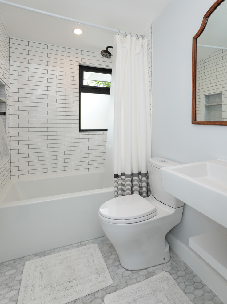 Пример оригинального дизайна: маленькая ванная комната в стиле неоклассика (современная классика) с ванной в нише, душем над ванной, унитазом-моноблоком, белой плиткой, керамической плиткой, серыми стенами, мраморным полом, душевой кабиной, подвесной раковиной, серым полом и шторкой для ванной для на участке и в саду