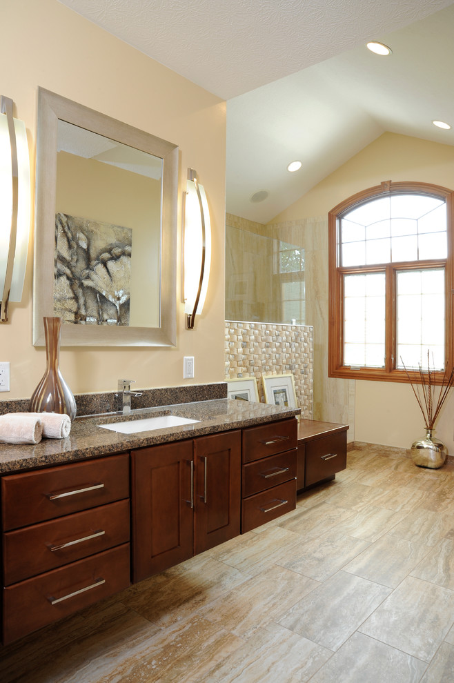 Inspiration pour une salle de bain principale traditionnelle en bois foncé de taille moyenne avec un plan de toilette en granite, un placard avec porte à panneau surélevé, une douche d'angle, un mur beige, un sol en carrelage de porcelaine et un lavabo encastré.
