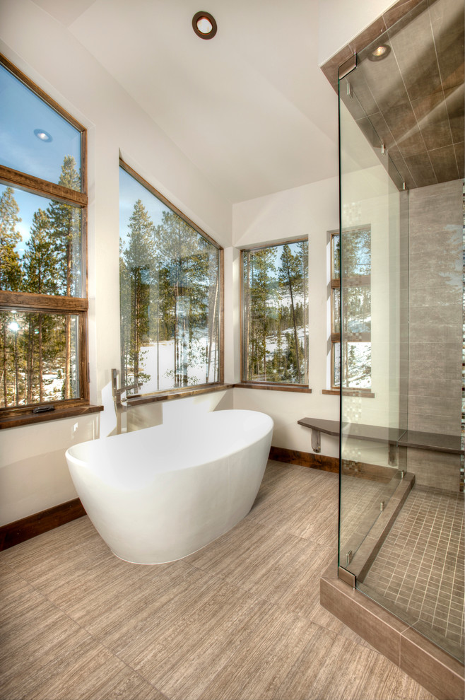 На фото: ванная комната в классическом стиле с отдельно стоящей ванной и керамогранитной плиткой с