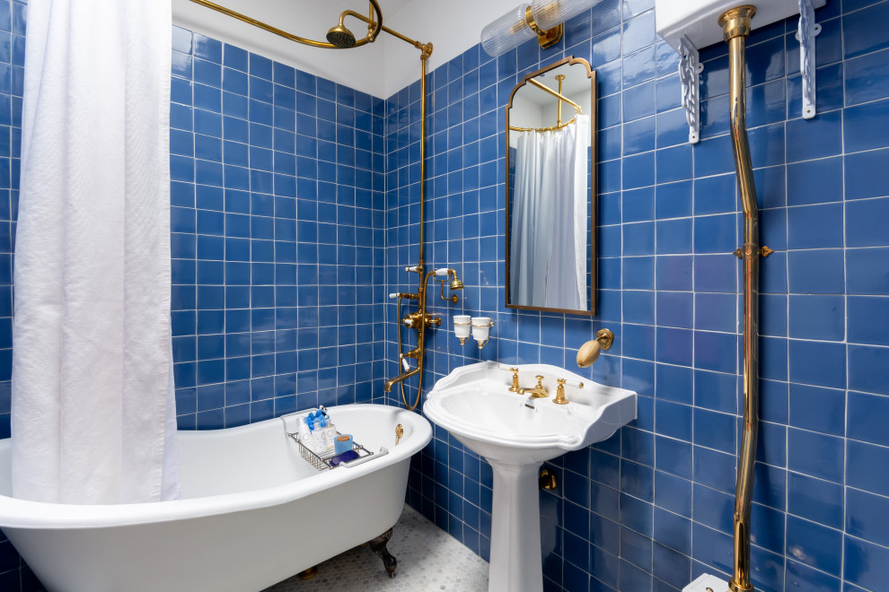 Exempel på ett klassiskt badrum, med ett badkar med tassar, blå kakel, blå väggar, mosaikgolv, ett piedestal handfat och vitt golv