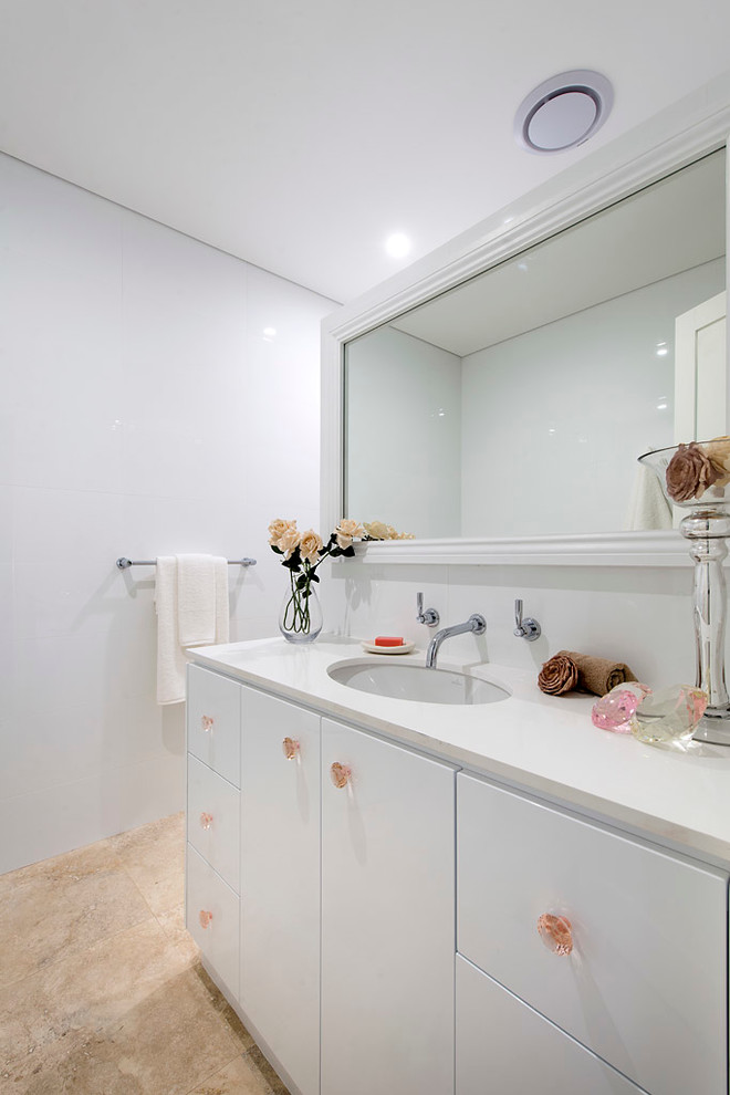 Imagen de cuarto de baño infantil contemporáneo grande con lavabo bajoencimera, armarios con paneles lisos, puertas de armario blancas, baldosas y/o azulejos blancos y paredes blancas