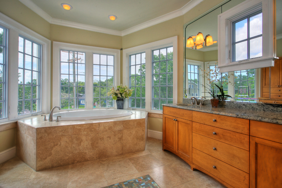 Modelo de cuarto de baño exótico con puertas de armario de madera oscura, baldosas y/o azulejos beige y bañera encastrada