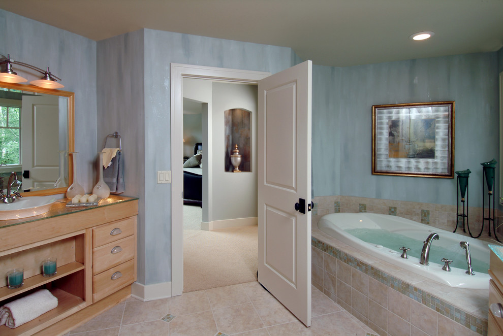 Esempio di una stanza da bagno padronale tradizionale di medie dimensioni con ante con riquadro incassato, ante in legno chiaro, vasca da incasso, piastrelle grigie, piastrelle in pietra, pareti blu, pavimento con piastrelle in ceramica, top in marmo e lavabo a bacinella