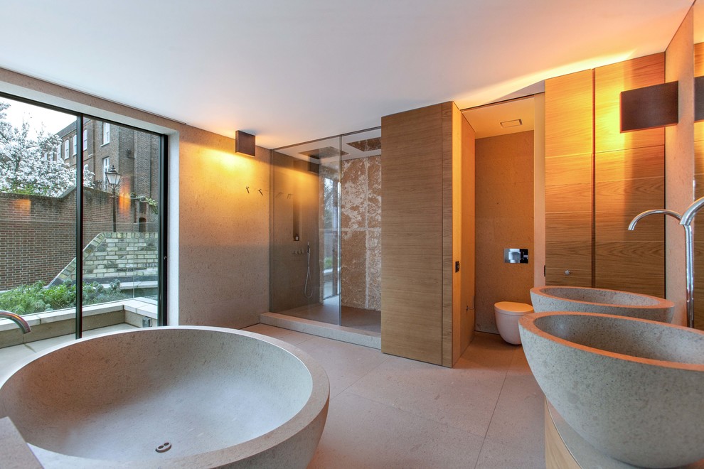 This is an example of a contemporary ensuite bathroom in London with flat-panel cabinets, an alcove shower, a wall mounted toilet, beige walls and a vessel sink.
