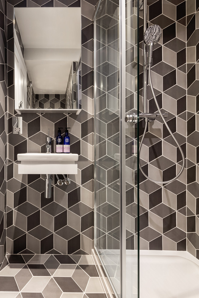Modern inredning av ett litet badrum med dusch, med en hörndusch, svart kakel, grå kakel, keramikplattor, ett väggmonterat handfat, flerfärgat golv och dusch med skjutdörr