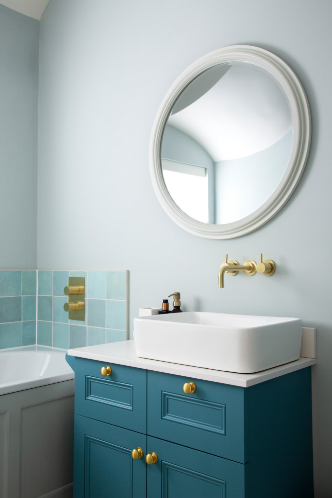 Ispirazione per una piccola stanza da bagno con doccia chic con ante con riquadro incassato, ante blu, vasca da incasso, piastrelle blu, piastrelle verdi, piastrelle in ceramica, pareti blu, lavabo a bacinella e top bianco