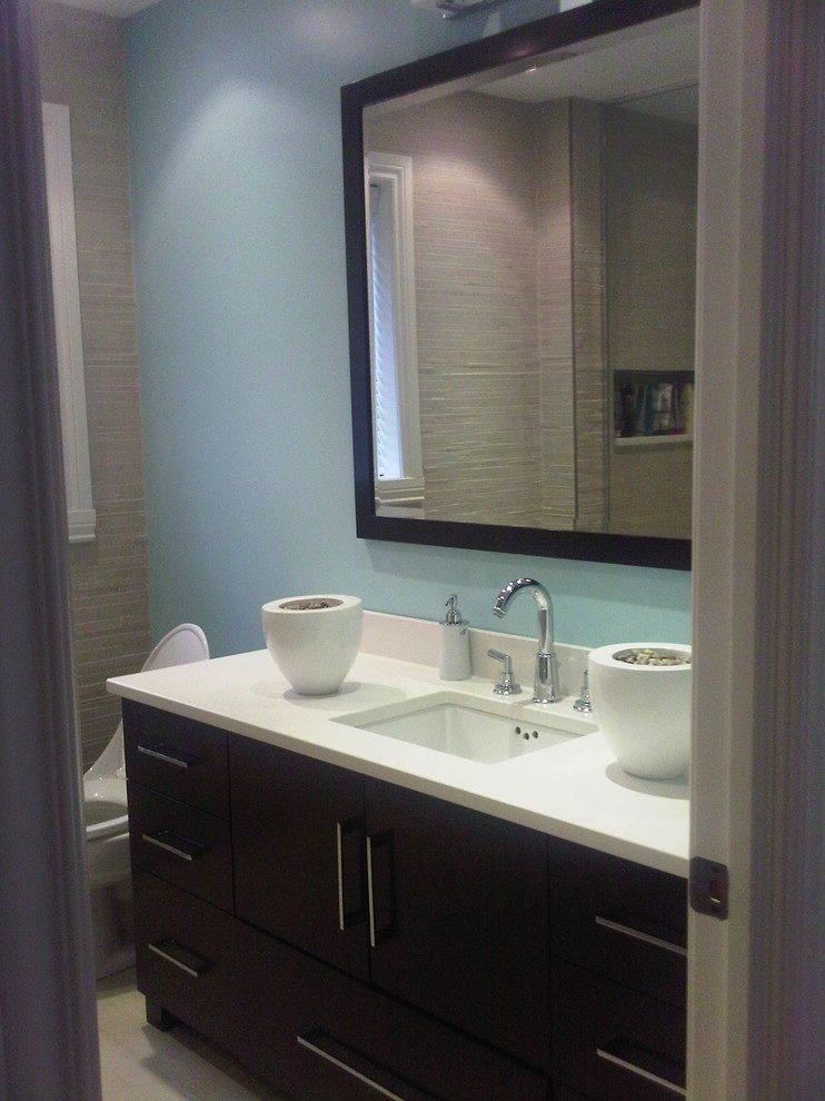Cette photo montre une salle de bain tendance en bois foncé de taille moyenne avec un placard à porte plane, un mur bleu, un lavabo encastré et une cabine de douche à porte battante.