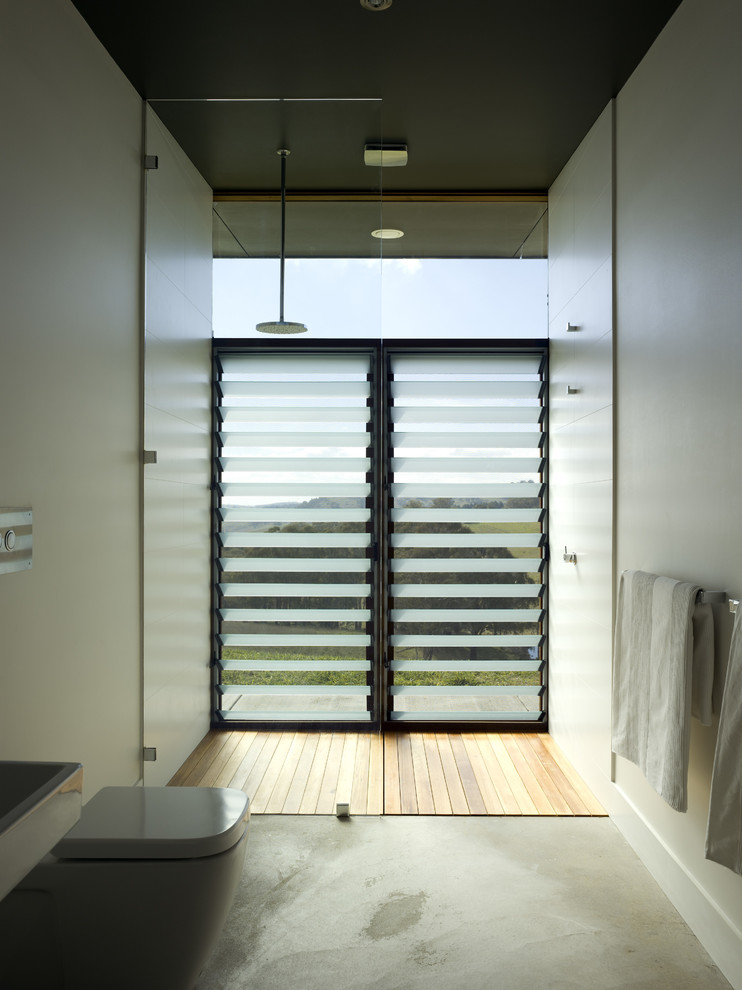 Idée de décoration pour une salle de bain design avec une douche ouverte, WC suspendus, un carrelage blanc, des carreaux de céramique, un mur blanc, sol en béton ciré et aucune cabine.