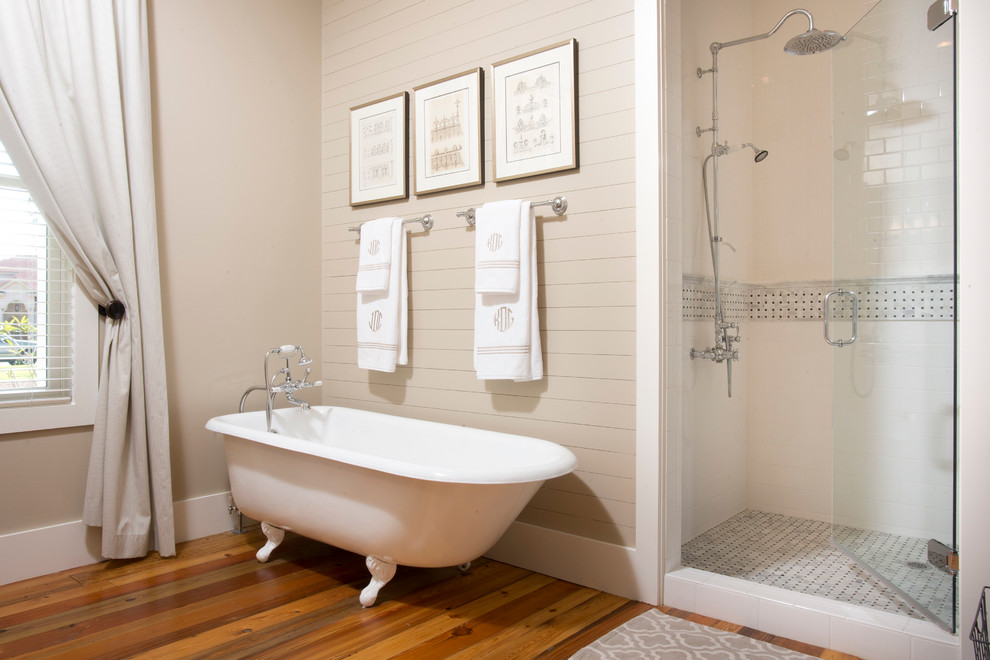 Réalisation d'une douche en alcôve principale champêtre de taille moyenne avec une baignoire sur pieds, un carrelage blanc, un carrelage métro, un mur gris et un sol en bois brun.