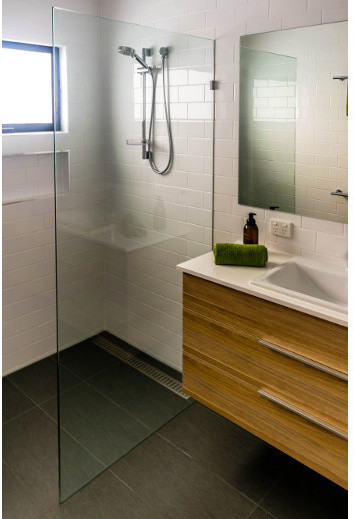 На фото: ванная комната в современном стиле с плоскими фасадами, светлыми деревянными фасадами, открытым душем, белой плиткой, плиткой кабанчик, белыми стенами, монолитной раковиной и столешницей из гранита