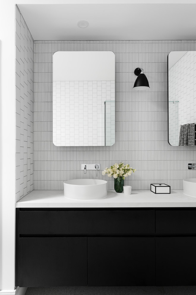 Inredning av ett modernt stort vit vitt en-suite badrum, med släta luckor, svarta skåp, vit kakel, vita väggar, terrazzogolv, bänkskiva i kvarts, grått golv, mosaik och ett fristående handfat