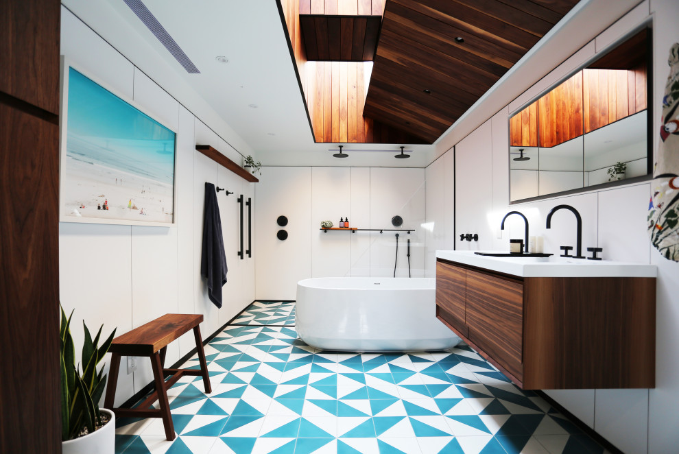 Пример оригинального дизайна: ванная комната в современном стиле с плоскими фасадами, темными деревянными фасадами, отдельно стоящей ванной, двойным душем, белой плиткой, белыми стенами, полом из цементной плитки, разноцветным полом, открытым душем и белой столешницей