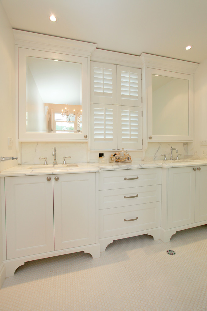 Imagen de cuarto de baño tradicional de tamaño medio con armarios con paneles empotrados, encimera de mármol, baldosas y/o azulejos blancos y paredes blancas