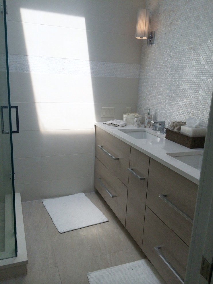 Idéer för att renovera ett mellanstort funkis badrum med dusch, med släta luckor, vita skåp, en dusch i en alkov, en toalettstol med hel cisternkåpa, grå kakel, porslinskakel, vita väggar, klinkergolv i porslin, ett undermonterad handfat, bänkskiva i täljsten, grått golv och dusch med gångjärnsdörr