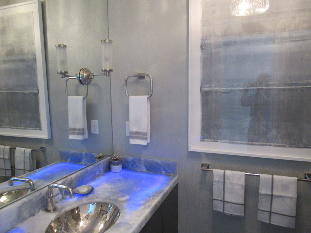 Cette photo montre une petite salle de bain chic avec un placard à porte plane, des portes de placard marrons, WC séparés, un mur gris, un sol en bois brun, un lavabo encastré, un plan de toilette en onyx, un sol marron, un plan de toilette bleu, meuble simple vasque, meuble-lavabo suspendu, un plafond décaissé et du papier peint.