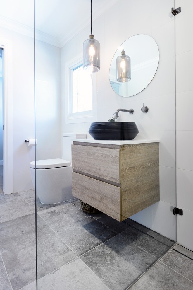 Inspiration for a medium sized eclectic ensuite bathroom with flat-panel cabinets, light wood cabinets, a double shower, a one-piece toilet, white tiles, ceramic tiles, white walls, ceramic flooring, a vessel sink, solid surface worktops, beige floors and a hinged door.