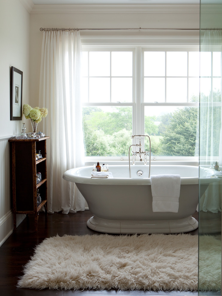 Cette photo montre une très grande salle de bain principale chic avec une baignoire indépendante, un mur beige et parquet foncé.