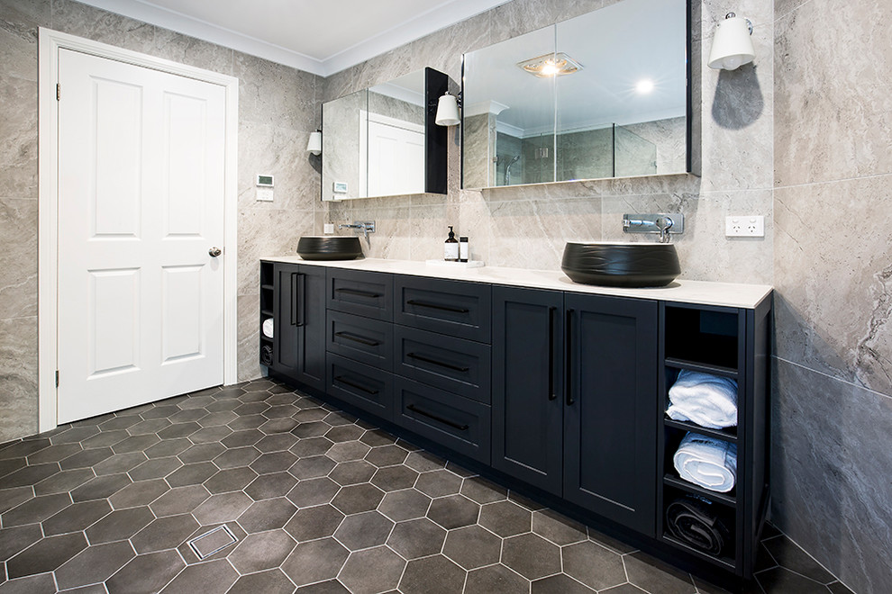 Exemple d'une salle d'eau moderne de taille moyenne avec un placard à porte shaker, des portes de placard noires, une douche d'angle, un carrelage gris, des carreaux de céramique, un mur gris, un sol en carrelage de céramique, une vasque, un plan de toilette en quartz modifié, un sol gris et une cabine de douche à porte coulissante.