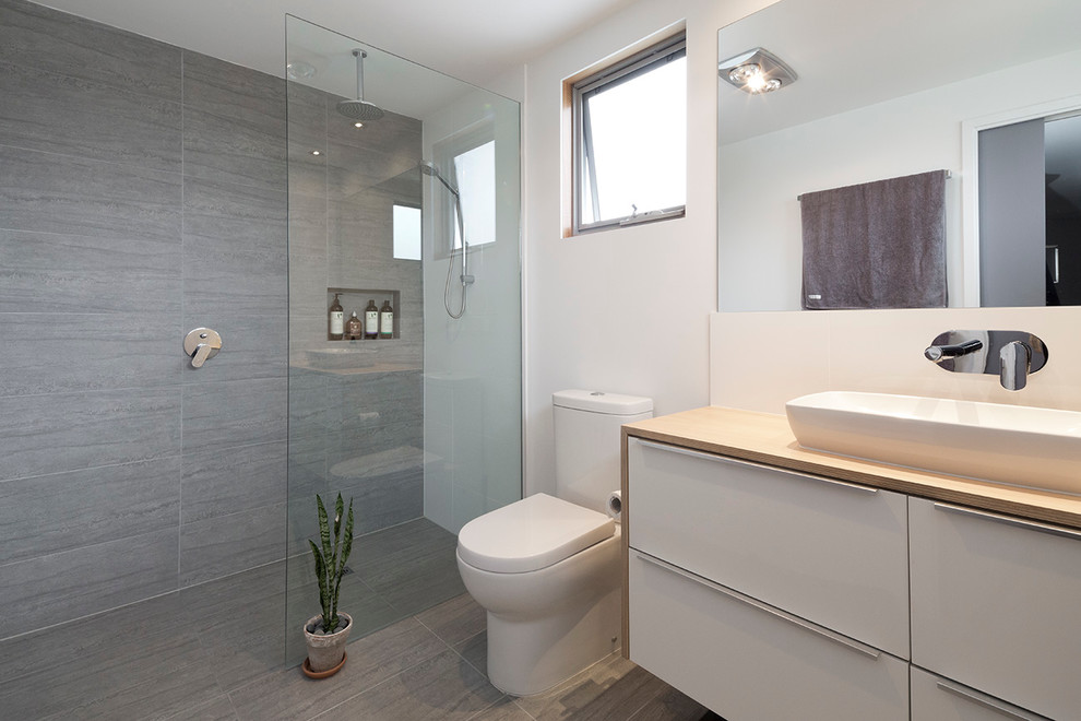 Idéer för ett litet modernt en-suite badrum, med ett nedsänkt handfat, vita skåp, träbänkskiva, en dusch i en alkov, grå kakel, keramikplattor, vita väggar och klinkergolv i keramik