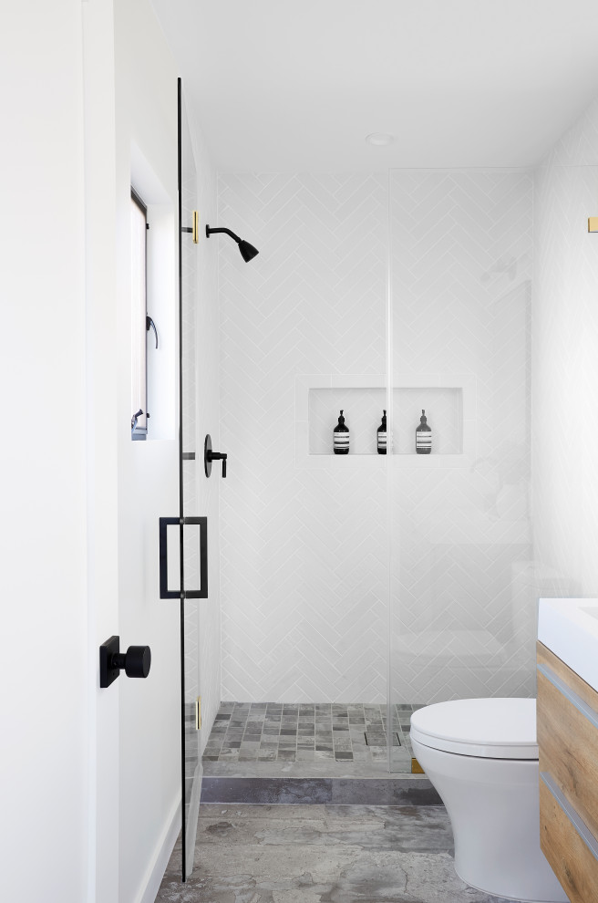 Idéer för att renovera ett litet funkis vit vitt badrum med dusch, med släta luckor, skåp i mellenmörkt trä, en dusch i en alkov, en toalettstol med hel cisternkåpa, vita väggar, betonggolv, ett integrerad handfat, bänkskiva i akrylsten, grått golv och dusch med gångjärnsdörr