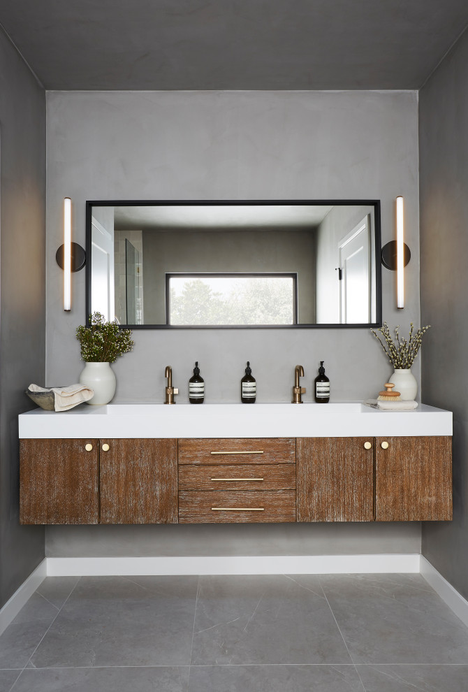Modern inredning av ett mellanstort vit vitt en-suite badrum, med släta luckor, skåp i mellenmörkt trä, grå väggar, ett integrerad handfat, bänkskiva i akrylsten och grått golv