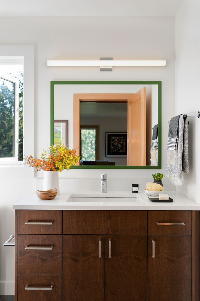 Imagen de cuarto de baño vintage con armarios con paneles lisos, puertas de armario de madera en tonos medios, paredes blancas, lavabo bajoencimera y encimeras blancas