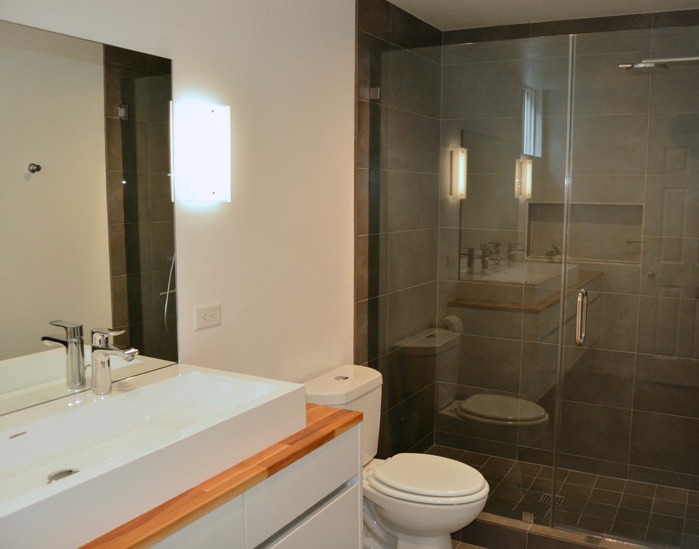 Idee per una stanza da bagno scandinava con lavabo a bacinella, ante lisce, ante bianche, top in legno, piastrelle grigie, pareti bianche e pavimento con piastrelle in ceramica